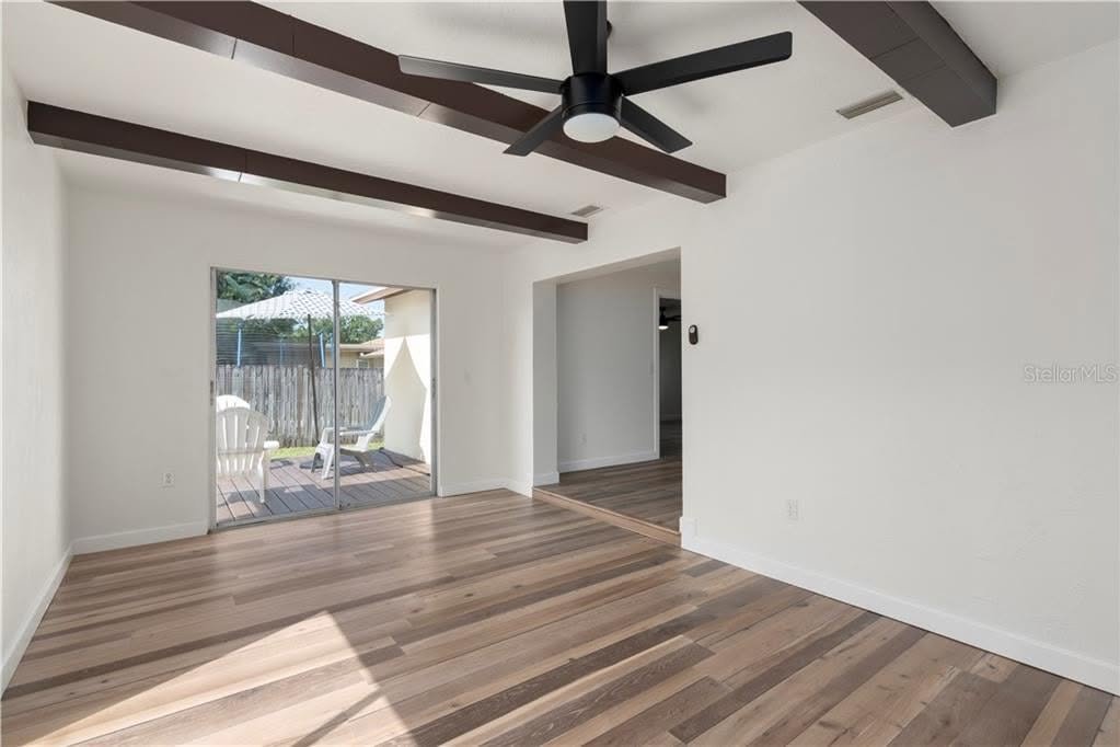 Empty living room with wood beams from one of Samantha's listings